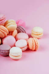 Sweet macaroons with vintage pastel colored tone on pink background.
