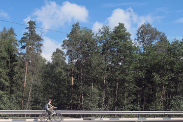 Fototapeta na wymiar teenager riding a bicycle along the edge of the highway