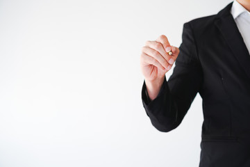 Young business man in black suit holding pencil and writes on blank glass screen.