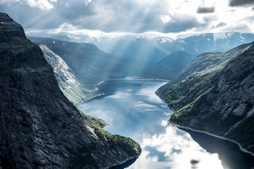 Beautiful fjord in Norway with amazing sun rays. View from the top - obrazy, fototapety, plakaty