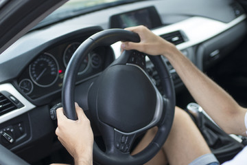 closeup of driver's hands on car steering wheel