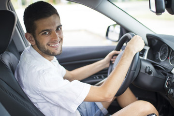 young adult smiling inside the car driving