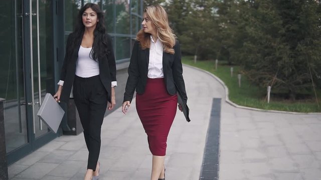 confident business women walking down the street. slow motion
