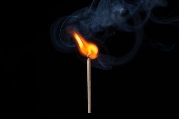 Start of flaming with smoke of matchstick on black background