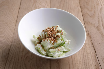 Salad with cucumber, salad leaves, celery and sunflower seeds