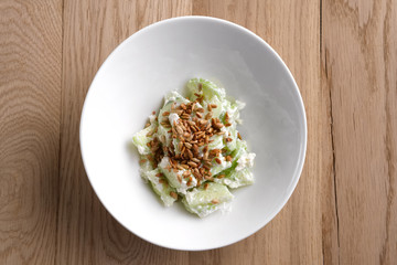 Salad with cucumber, salad leaves, celery and sunflower seeds