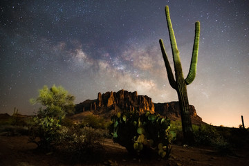 A starry night time desert landscape with the milkyway.  Milkyway rising behind the superstition mountains. Arizona