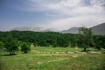 Majestic landscape of the mountains and forest in Caucasus at summer. Dramatic sky with clouds.