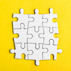 Connected blank puzzle pieces on a yellow background