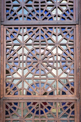  Background of stained glass. Wooden openwork window with multi-colored glass.
