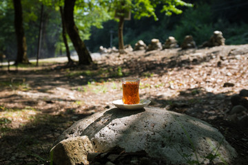 Eastern black tea in glass on a eastern carpet. Eastern tea concept. Armudu traditional cup. Sunset background. Selective focus