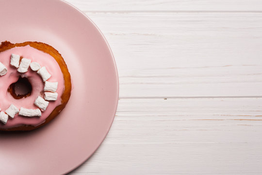 Pink donut with marshmallows on a Pink plate