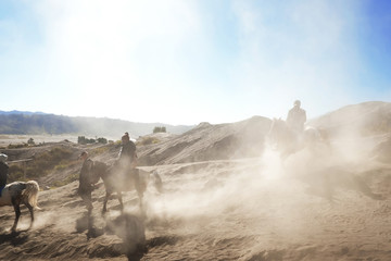 Tourists, relying on the horses to travel across the desert of Bromo Valcano, Indonesia