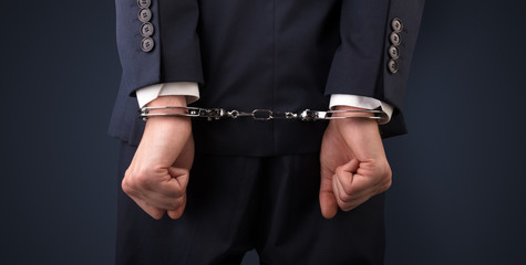 Close now arrested men hand with dark background and handcuffs

