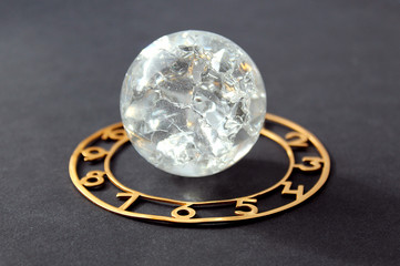 glass ball surrounded by a dial lies on a black background