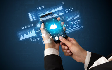Female hand using smartphone with financial tracking concept illustrated by graphs and symbols