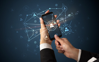 Female hand using smartphone to connect peoples all around the online surface
