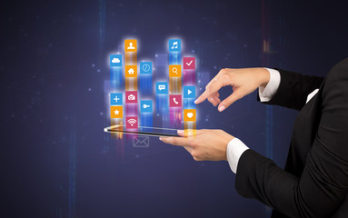 Female elegant hand holding tablet with colourful application icons