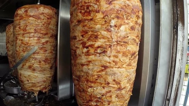 Gyros Preparation in Greek Street Restaurant / A gyro or gyros is a Greek dish made of meat cooked on a vertical rotisserie, traditionally pork, or chicken