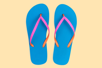 Blue flip flops isolated on yellow background. Top view