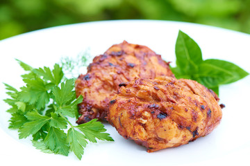 Grilled chicken Legs with herbs on a plate.