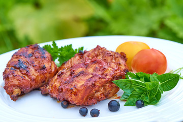 Grilled chicken Legs with herbs on a plate.