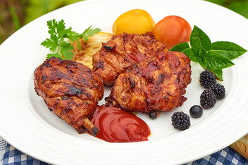 Grilled chicken Legs with spices and herbs on a plate.