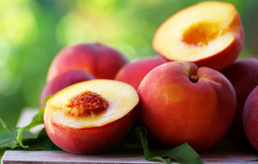 ripe peaches and slices on table