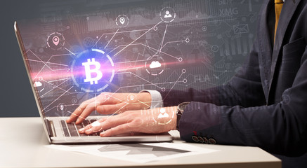 Hand checking on laptop global bitcoin exchange rate concept
