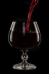 Naklejka na ściany i meble Glass still life image A glass of red wine in a glass on a black background