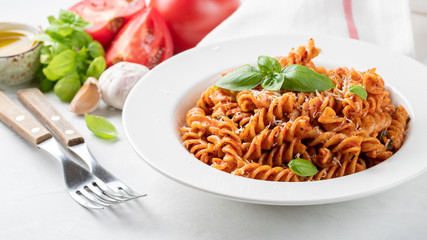 Fusilli pasta with tomato sauce, garlic, Basil and Parmesan cheese on white background
