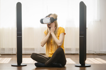 Girl wearing virtual reality goggles at home