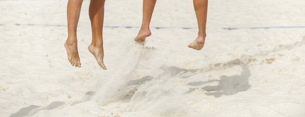 Close-up of feet and legs of a male beach volleyball player
