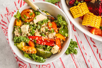 Healthy vegan salad with roasted vegetables, tahini, quinoa and kale. Clean eating concept.