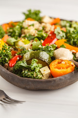 Healthy vegan salad with roasted vegetables, tahini, quinoa and kale. Clean eating concept.