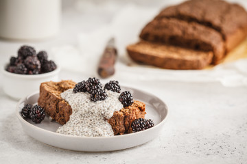 Chocolate vegan banana bread with chia pudding and blackberries, white background.