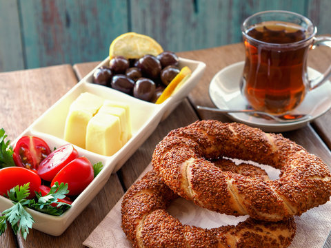 turkish bagel on wooden table, tea and breakfast plate. Tomatoes, cheese, olives
