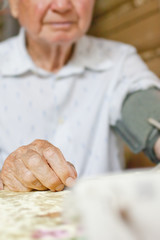 Man measuring blood pressure with tonometer herself