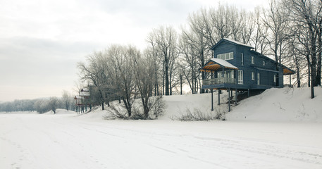 Wooden cottages in winter time, lake gateway 