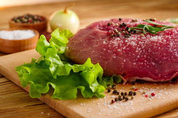 raw fresh meat on the table for cooking with salad and spices