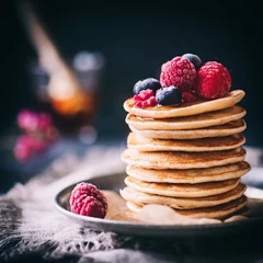 Foto auf Acrylglas Dessert Gestapelte Pancakes mit fruschen Beeren und Ahornsirup auf dunklem Hintergrund