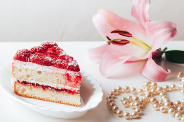 Strawberry sweet dessert in a small plate and a pink flower. close-up on a white background.