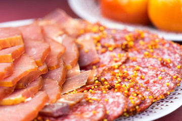 Sliced sausage lying on a plate. seasoned with mustard seeds. close-up photo