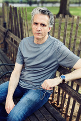 Grey Haired Man Sits on Park Bench