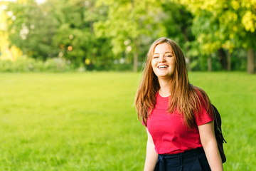 Fototapeta premium Happy student girl with notes and backpack. Entering the university, starting school in September