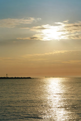 Sunset over the sea. Reflection of sunlight in the sea waves. Red sky in the rays of the sunset.
