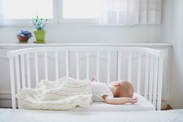 Obraz na płótnie Canvas Baby girl sleeping in co-sleeper crib