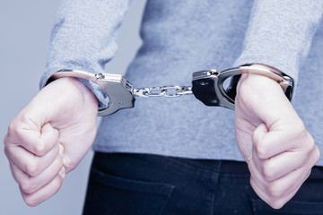 Teen with her hands handcuffed in criminal concept