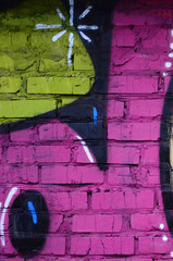 Fragment of graffiti drawings. The old wall decorated with paint stains in the style of street art culture. Colored background texture