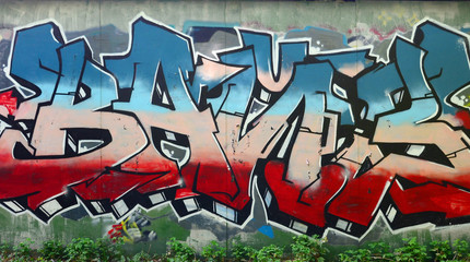 Full and acomplished graffiti artwork. The old wall decorated with paint stains in the style of street art culture. Colored background texture